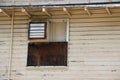 Old, abandoned wooden barrack, with boarded up window and an old air conditioner. Royalty Free Stock Photo