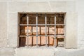 Old abandoned wooden box with glass of rusty metal bars in the concrete wall in a building of ancient architecture in Lviv Royalty Free Stock Photo