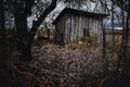 Old abandoned wooden cabin in a view of old scary trees