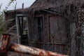 An old abandoned wooden country house made of darkened dried planks with boarded and broken windows and no door on a dark day and Royalty Free Stock Photo