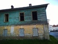 Old abandoned wooden dirty two-storied house without windows. Building exterior. Dirty broken wall. Messy. Poverty and economic Royalty Free Stock Photo