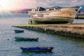 Old abandoned wooden fishing boat with wooden fishing boats on the shore at sunset Royalty Free Stock Photo