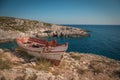 The old abandoned wooden fishing boat on a rocky cliff shore on a sunny day in greece. Zakynthos. Blue sea in the Royalty Free Stock Photo