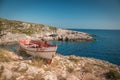 The old abandoned wooden fishing boat on a rocky cliff shore on a sunny day in greece. Zakynthos. Blue sea in the Royalty Free Stock Photo