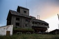 The old abandoned granary in the rays of sunset, like a moving castle. Wooden fence in the foreground Royalty Free Stock Photo