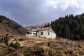 Old abandoned wooden house against the background of trees and a cloudy sky. Rural landscape. Gloomy house Royalty Free Stock Photo