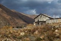 Old abandoned wooden house against the background of trees and a cloudy sky. Rural landscape. Gloomy house Royalty Free Stock Photo