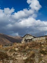 Old abandoned wooden house against the background of trees and a cloudy sky. Rural landscape. Gloomy house Royalty Free Stock Photo