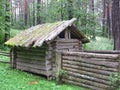 An old abandoned wooden house made of logs in the forest overgrown with grass covered with moss a Forester`s hut Royalty Free Stock Photo