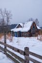 Old abandoned wooden house. The roof is covered with a thick layer of snow. Altai village Ust\'-Lebed\' in winter season Royalty Free Stock Photo