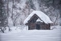 Old abandoned wooden house. The roof is covered with a thick layer of snow. Altai in winter season Royalty Free Stock Photo