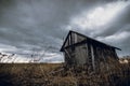 Old abandoned wooden house in a view of dark cloudy sky