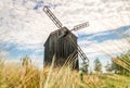 Old abandoned wooden mill and wheat summer field Royalty Free Stock Photo