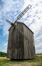 Old abandoned wooden mill and wheat summer field Royalty Free Stock Photo