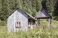 Old abandoned wooden village house surrounded by green forest in the Carpathian mountains Royalty Free Stock Photo