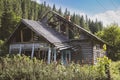 Old abandoned wooden village house surrounded by green forest in the Carpathian mountains Royalty Free Stock Photo