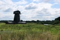 Old abandoned wooden windmill in the field by the river Royalty Free Stock Photo