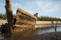 Old abandoned wreck ship unused small boat at sea coast