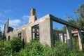 Old abandoned wrecked house in the field overgrown with green ivy Royalty Free Stock Photo