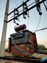 An old transformer with high voltage wires.