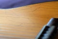 Old acoustic guitar with cracks on the soundboard