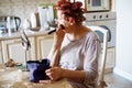 Old active senior woman with rollers in hair take care of herself on her day off. Make up with brush, looking at mirror Royalty Free Stock Photo