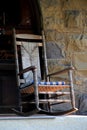 Old Adirondack rocking chair against stone wall Royalty Free Stock Photo