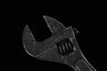 Old adjustable spanner on a black background Royalty Free Stock Photo