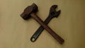 Old adjustable wrench and old hammer form a cross formation Royalty Free Stock Photo