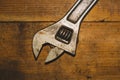 Old adjustable wrench on a wooden background. working tool. plumbing repairing instrument Royalty Free Stock Photo