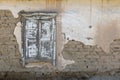 old adobe building wall with old shabby closed wooden window and peeled off plaster Royalty Free Stock Photo