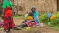 Old African woman from Masai tribe holding a baby in her village