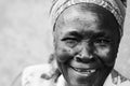 A old African woman smiles with a toothless grin