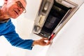 Old age handyman repair vent hood in the kitchen