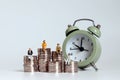 Old age miniatures sitting on a pile of coins with alarm clock. Royalty Free Stock Photo
