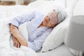 senior woman with eye mask sleeping in bed at home Royalty Free Stock Photo