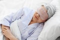 senior woman with eye mask sleeping in bed at home Royalty Free Stock Photo