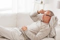 Senior man lying on sofa and thinking at home Royalty Free Stock Photo