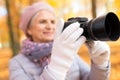 Senior woman with photo camera at autumn park Royalty Free Stock Photo