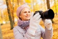 Senior woman with photo camera at autumn park Royalty Free Stock Photo