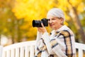 Senior woman with photo camera at autumn park Royalty Free Stock Photo