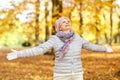 Happy senior woman enjoying beautiful autumn