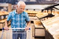 Elderly man buying bread and pastries in grocery section of the supermarket Royalty Free Stock Photo