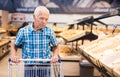old age senor examines bakery products in the grocery section of the supermarket Royalty Free Stock Photo