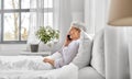 senior woman calling on smartphone in bed at home Royalty Free Stock Photo