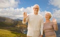 Senior couple waving hands over big sur coast Royalty Free Stock Photo