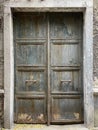 Old aged double winged wooden greenish closed door with metal handles Royalty Free Stock Photo