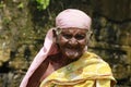 Old aged farmer woman smiling while standing outdoors in Gobichettipalayam, India