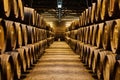 Old aged traditional wooden barrels with wine in a vault lined up in cool and dark cellar in Italy, Porto, Portugal, France