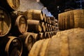 Old aged traditional wooden barrels with wine in a vault lined up in cool and dark cellar in Italy, Porto, Portugal, France